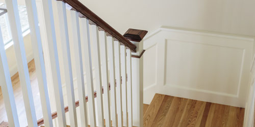 White stair spindals with a dark stained wood rail cap